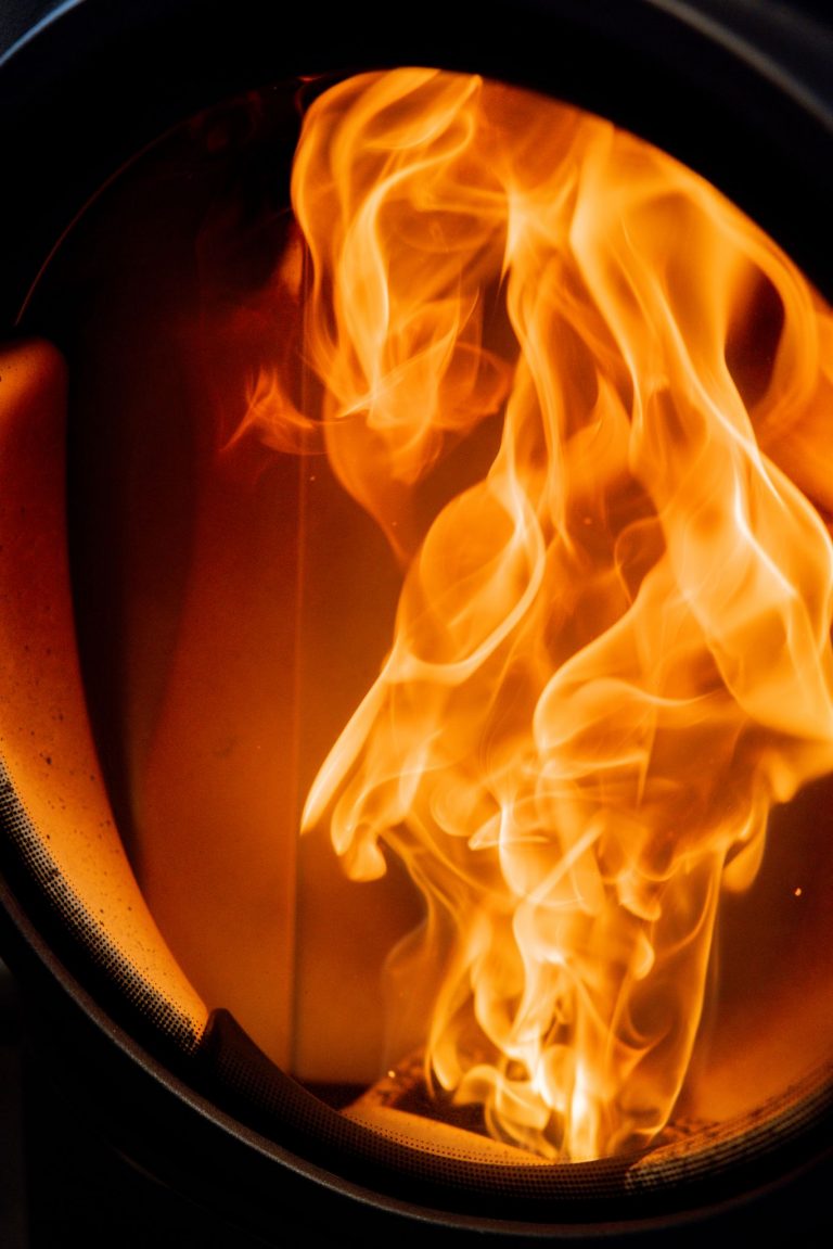 Close-up of bright flames dancing inside a furnace or industrial setting.