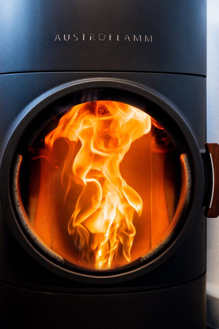 Vivid flames captured in an Austroflamm fireplace for a warm indoor ambiance.